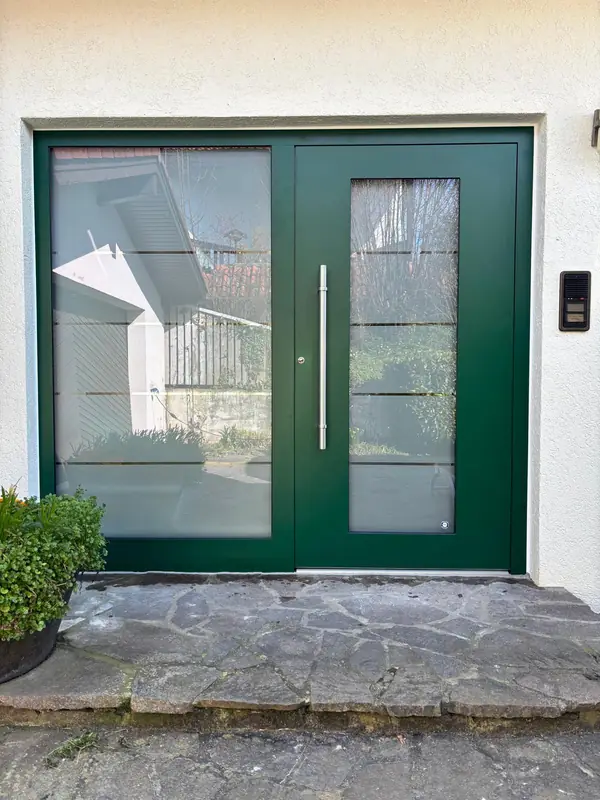 Grüne Haustür mit breitem Glas-Seitenteil und Edelstahlgriff